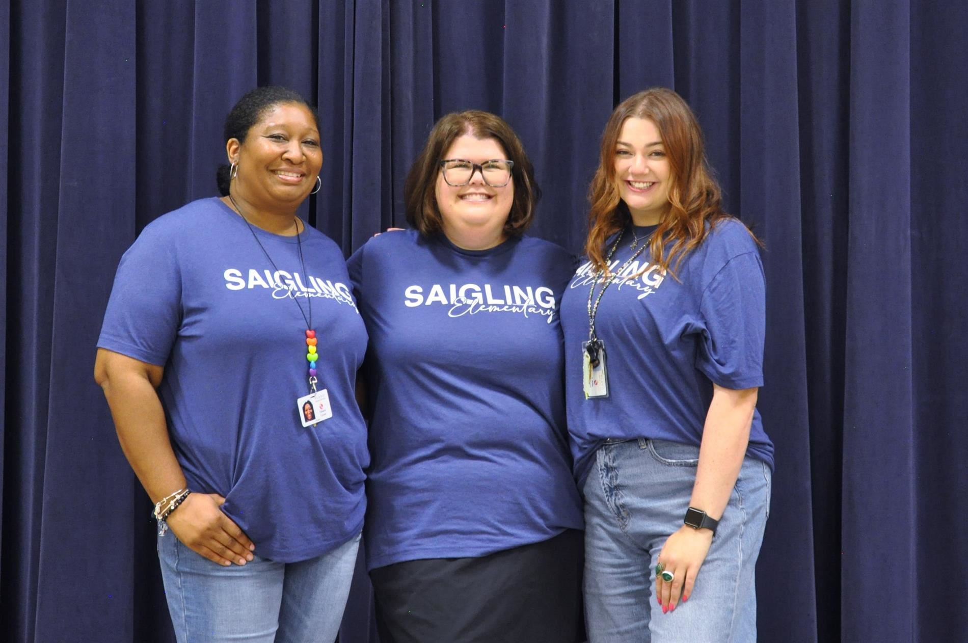A picture of Ms. Grant, Ms. Kuwitzky, and Ms. Hosid standing next to each other smiling.